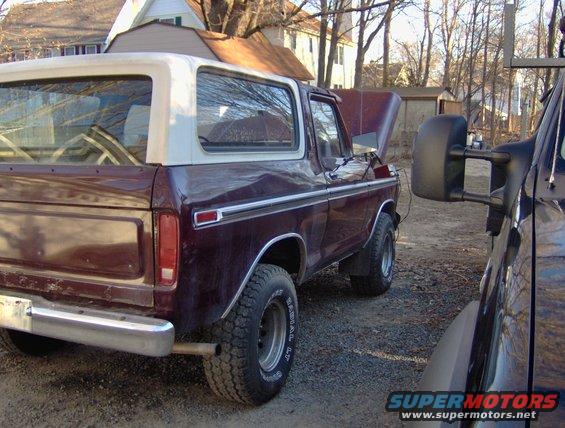 Maroon Ford Bronco with white top, hood open, parked next to another vehicle