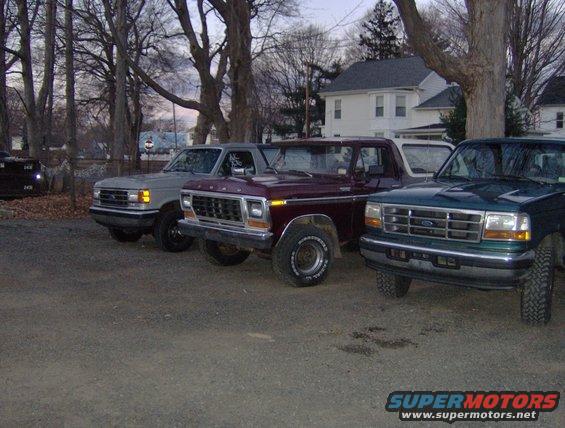 1996 Ford Bronco and two older Ford trucks parked outside