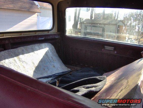 Interior of a vehicle with maroon upholstery and a folded blanket on the seat