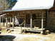 1995 Ford Bronco - A rustic log cabin porch features rocking chairs and a wooden bench, decorated with mounted antlers.