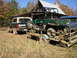 1995 Ford Bronco - A Ford Bronco is parked next to a trailer with a Polaris Ranger ATV on it, with a building in the background.