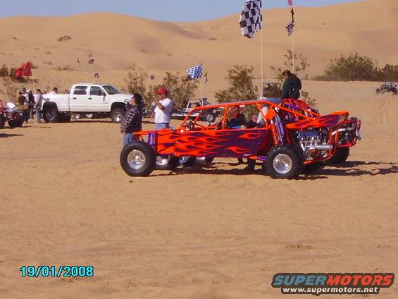 Orange dune buggy with purple flames, exposed engine, and roll cage