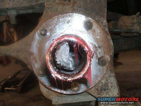 Wheel hub assembly with red grease and visible damage