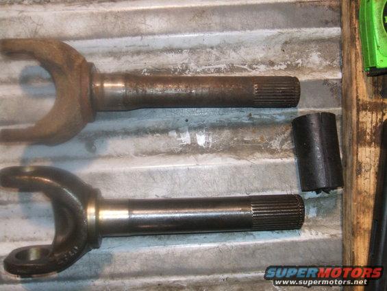 Two driveshaft yokes, one rusty and one clean, with a black spacer