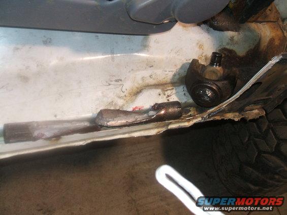 close-up of rusted metal on a vehicle frame with a suspension component visible