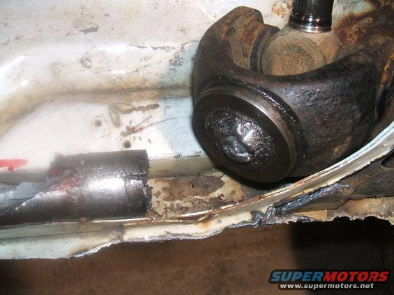 Driveshaft universal joint and damaged frame with rust and metal fatigue