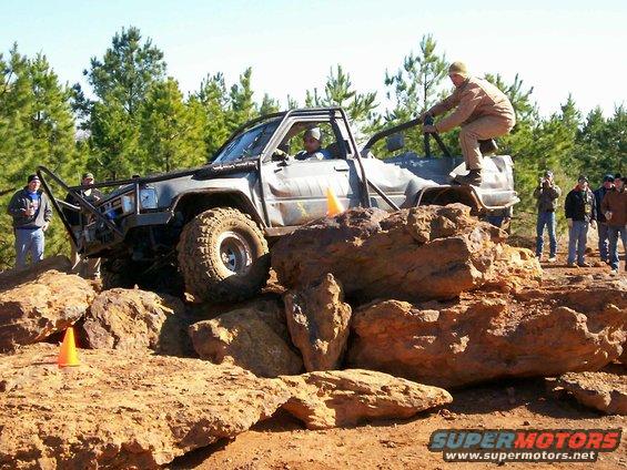Modified off-road truck climbing over large rocks