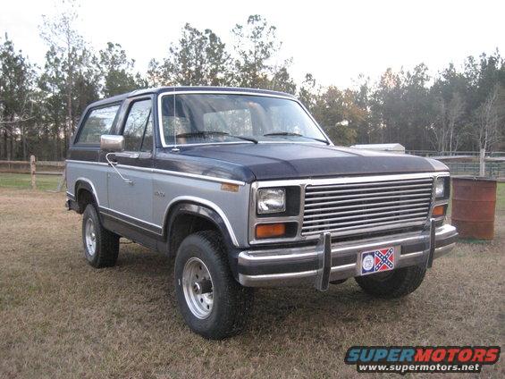 Two-tone blue and gray Ford Bronco with chrome grille and bumper, parked on grass