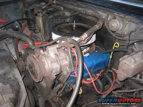 Engine bay with blue Ford valve covers, air filter, and AC compressor