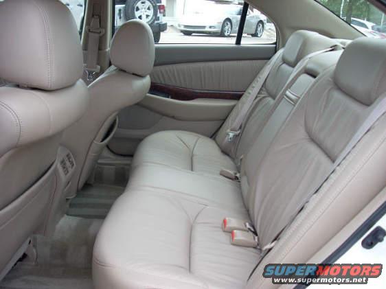 Interior rear seats and door panel of a car, with another vehicle visible through the window