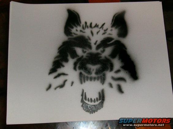 Stencil of a snarling wolf head with sharp teeth and fur detail