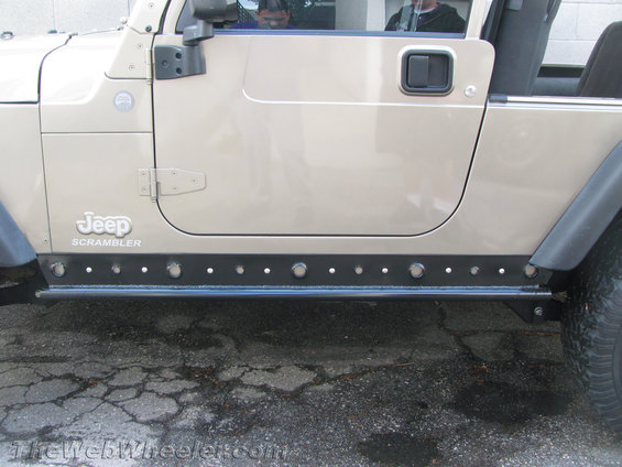 Tan Jeep Scrambler side view with rock sliders and visible "Jeep Scrambler" badging