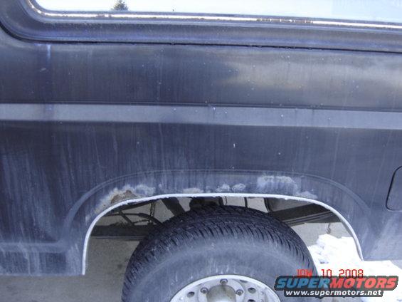1985 Ford Bronco rear wheel well showing rust and a tire