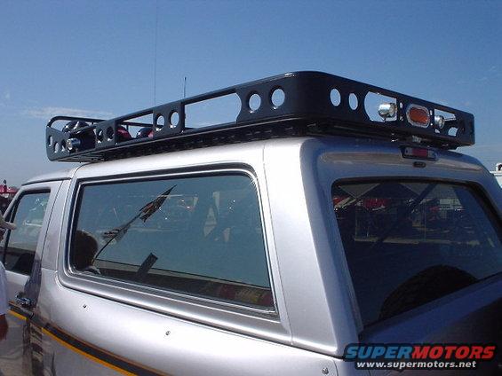 Silver Ford Bronco, third generation, with black roof rack and yellow stripe on lower body
