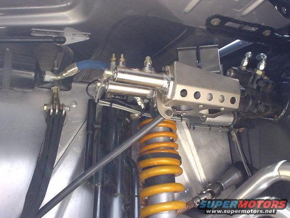Close-up of yellow coilover suspension and brake lines