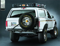 1986 Ford Bronco rear with spare tire mounted on swing-away carrier and roof rack