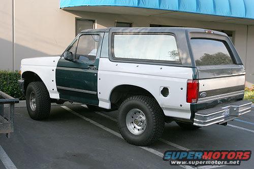 White and dark green Ford Bronco with aftermarket wheels and a chrome bumper