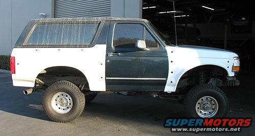 Bronco with mismatched body panels, one side is dark green, the other is white. Front fender is also white