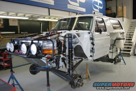 1986 Ford Bronco with front end disassembled, on jack stands, in a workshop