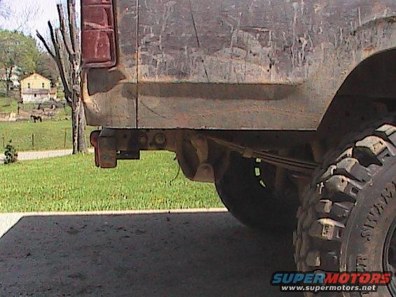 Rear of weathered pickup truck showing taillight and leaf springs