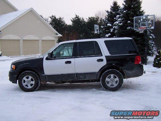 Side view of a 2004 Ford Expedition parked in the snow. The SUV has a two-tone paint job with black on the front and white on the rear