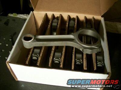 Box of connecting rods, one is in focus in the foreground