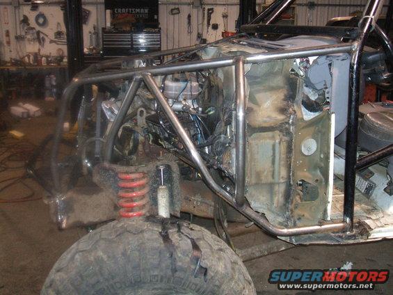 Off-road vehicle with roll cage and exposed engine bay, front view