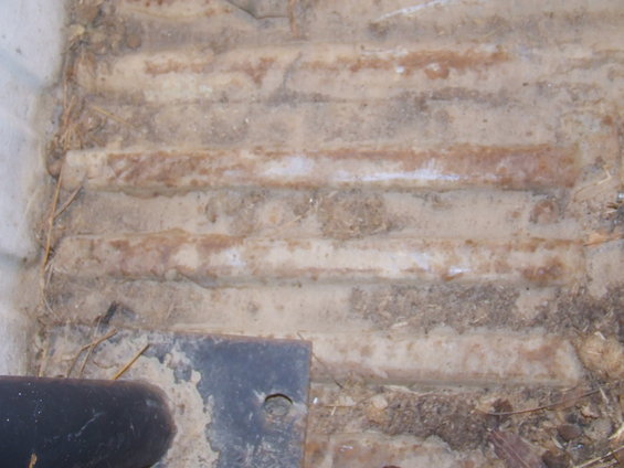 Corrugated metal floor with dirt and debris