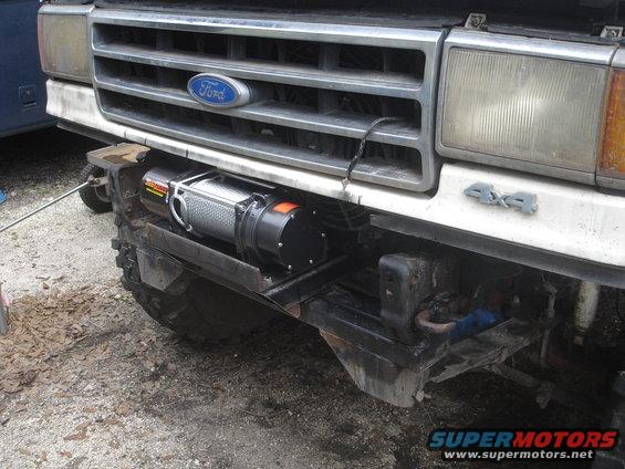 Ford truck front end with a winch mounted below the grille. 4x4 badge visible