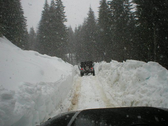 Black Jeep Wrangler driving through deep snow on a forest road. 2005 model