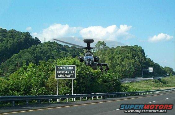 Helicopter flying over highway with speed limit enforced by aircraft sign