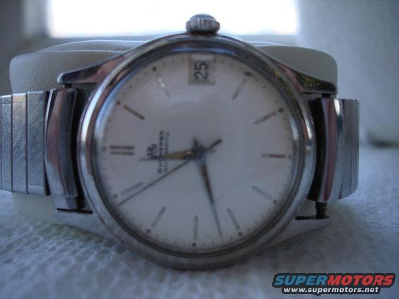 close-up of a white analog watch with a date window showing 25