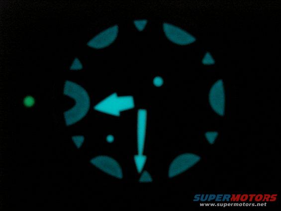 Illuminated gauge cluster with arrows and markers on black background