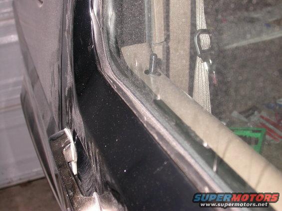 Interior door panel and window trim with visible clip and seatbelt anchor