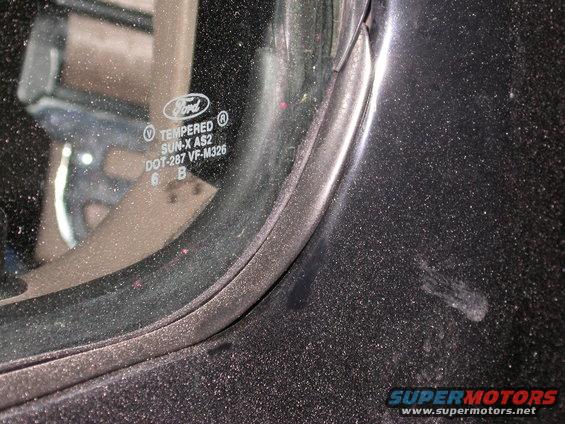 Black vehicle door frame with a close-up of tempered glass showing Ford logo and DOT codes