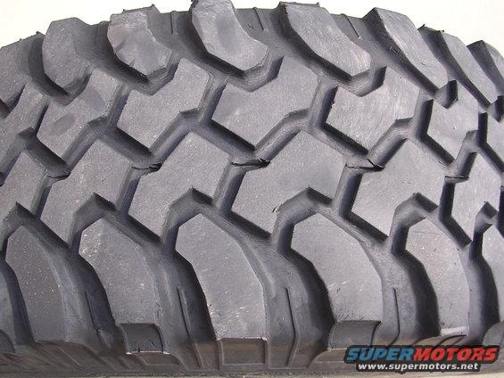 Tire tread with deep, aggressive lugs and sipes. The rubber shows some minor cracking