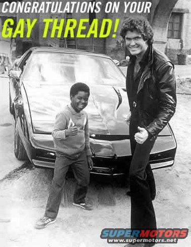 Black car with two people, one a young boy giving a thumbs up, the other a man in a leather jacket
