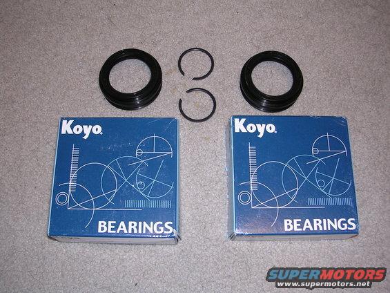 Two Koyo bearings boxes with two seals and two snap rings on a carpeted surface