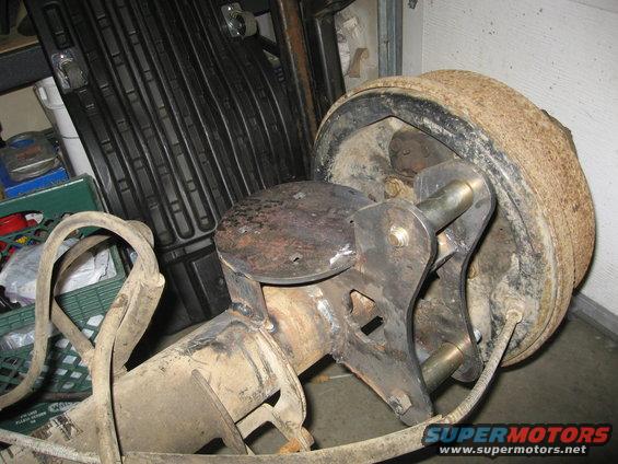 Close-up of a vehicle's rear axle assembly with a brake drum