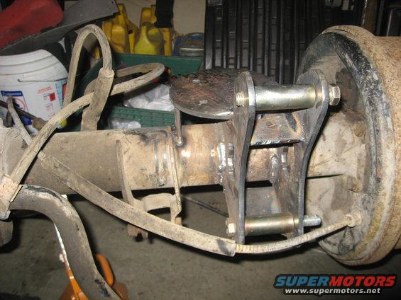 Rear axle assembly with custom bracketry and brake drum