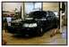 1998 Ford Crown Victoria - A black 2003 Ford Crown Victoria, equipped with a push bar, is raised on a car lift inside a workshop.