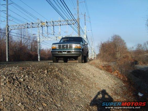 1996 Ford Bronco parked on gravel near railroad tracks under power lines