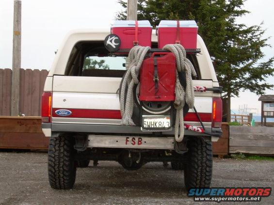 1991 Ford Bronco rear view with spare tire, red gas can, and two red coolers mounted on a rack. License plate reads 5WHK843