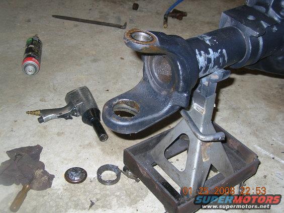 Dana 60 axle housing on jack stands with tools and parts scattered around