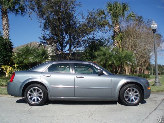 Silver Chrysler 300 sedan parked on a street, side view