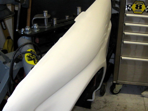 White fender part with visible wheel well and a metal toolbox to the right
