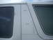 1992 Ford Bronco - Close-up view of the side panel of a white SUV, revealing two windows and visible rivets.