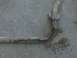 1996 Ford Bronco - A corroded metal pipe with a mounting bracket is visible against a concrete surface.