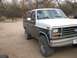 1982 Ford Bronco - This Ford Bronco is parked outside with trees and a dirt lot in the background.