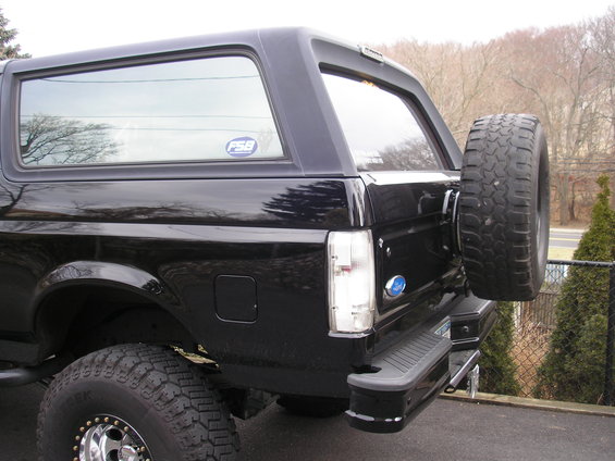 Black Ford Bronco, rear quarter view, spare tire mounted on back